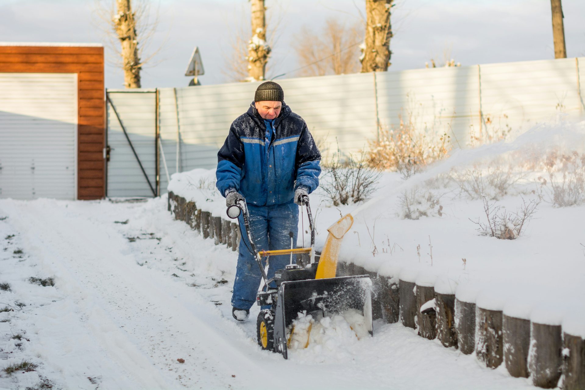 ein Mann, der mit einer Schneefräse Schnee schaufelt